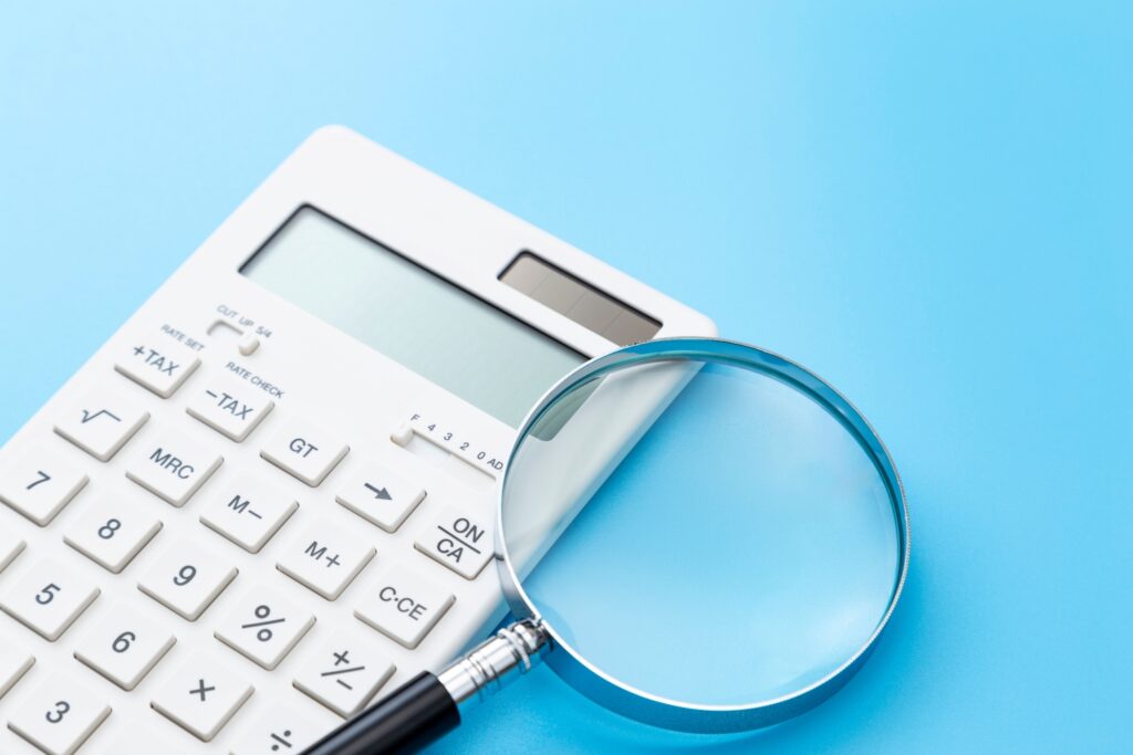 青背景に電卓と虫眼鏡